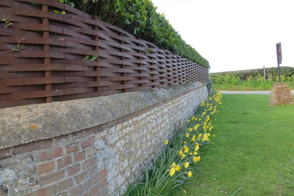 woven steel fence above wall