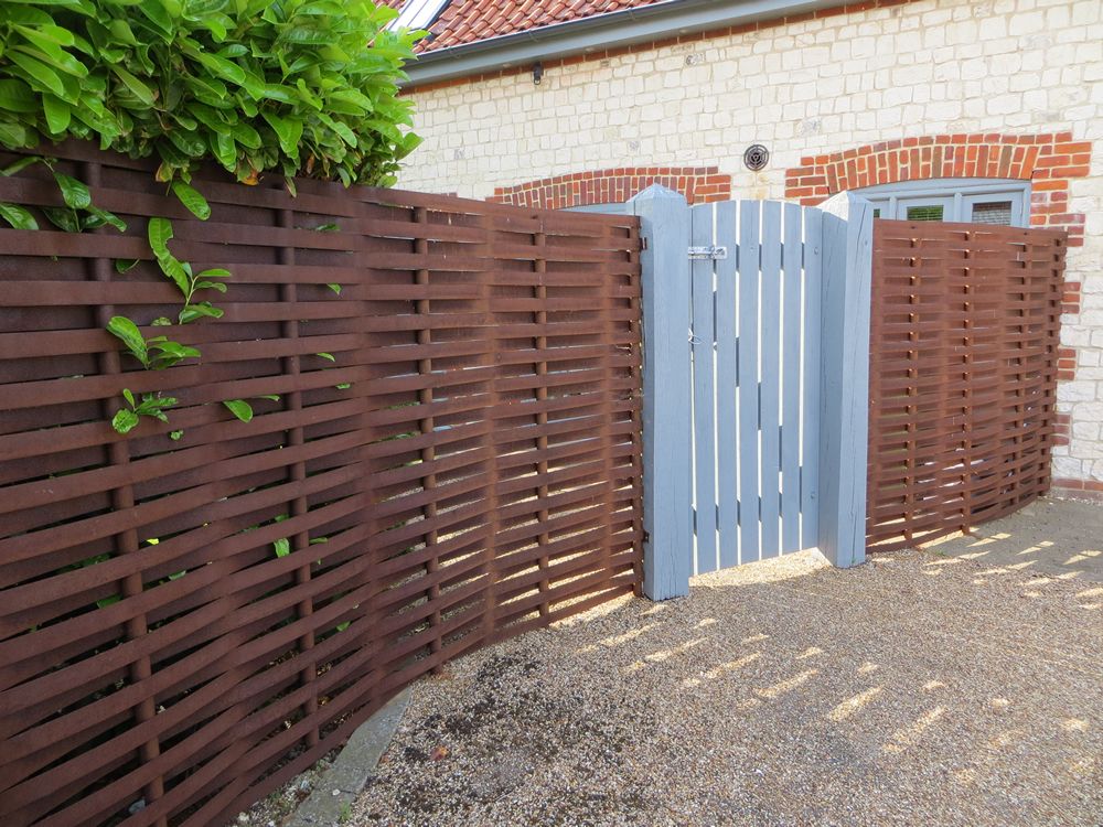 woven steel fencing and wooden gate